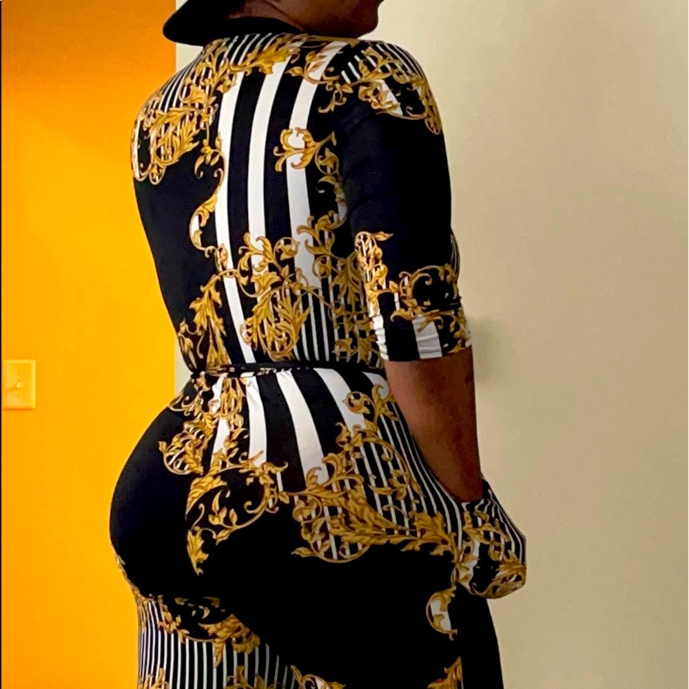 A Black, Gold, and White Janette Large Size body suit.